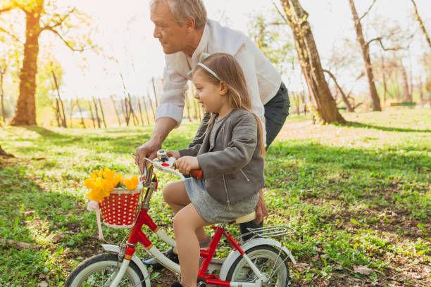 istock Man holding his granddaughter's bike 810854442