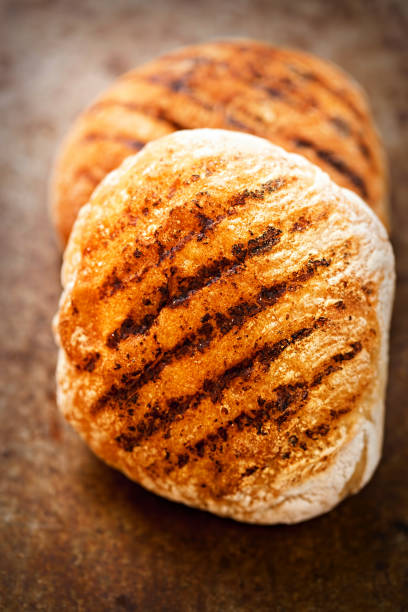 istock Grill burger bun with grill marks on vintage background 810869674