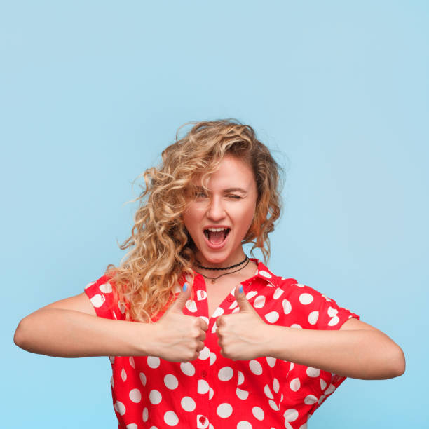 istock Woman winking holding thumbs up 810877408