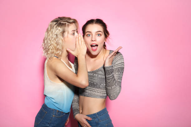 istock Young woman whispering to friend 810880322