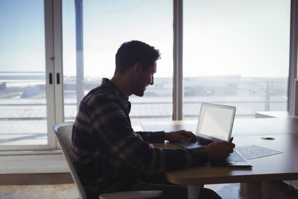 istock Young editor using digitizer and laptop on desk in office 810915716