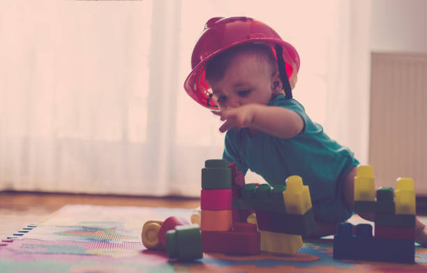 istock Cute baby boy playing with colorful plastic blocks 810919510