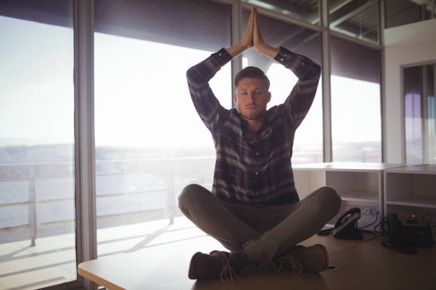istock Young businessman meditating on table at office 810919658