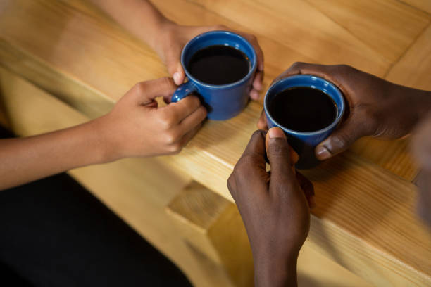 istock Couple hands holding coffee cups at table 810934050