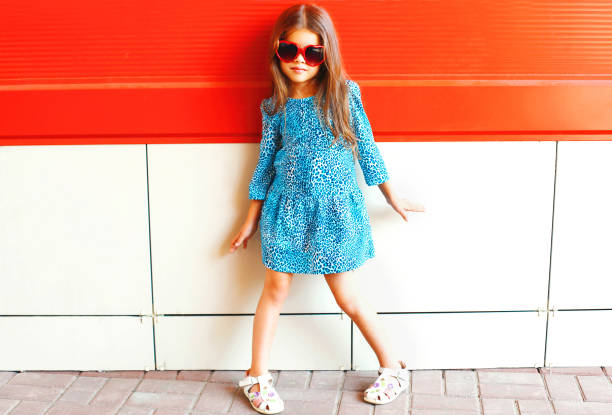 pequeña niña de moda en un vestido de leopardo con gafas de sol sobre un fondo rojo - women sunglasses little girls glamour fotografías e imágenes de stock