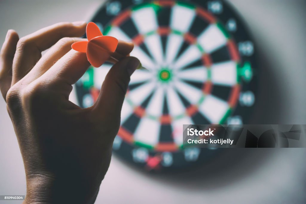 Target a hand holding arrow and pointing a darts Darts Stock Photo