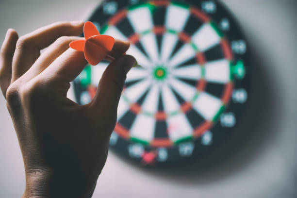 Target a hand holding arrow and pointing a darts dartboard photos stock pictures, royalty-free photos & images