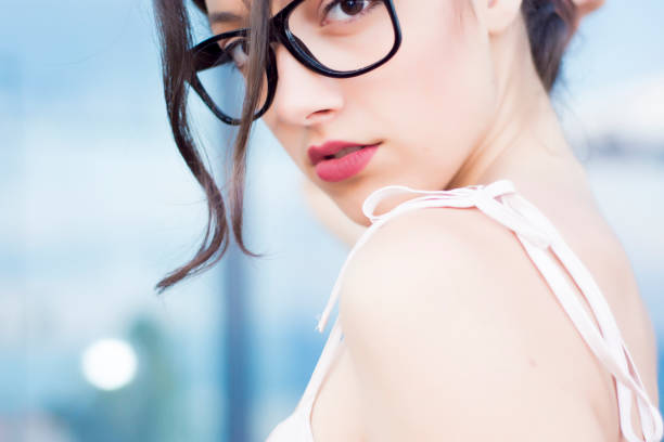 istock Girl with glasses looking over her shoulder 810940412
