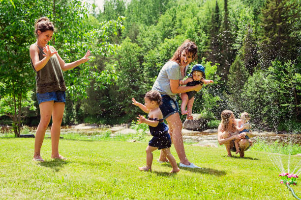 istock Millennials mothers enjoying springkling water with baby daughters. 810942804