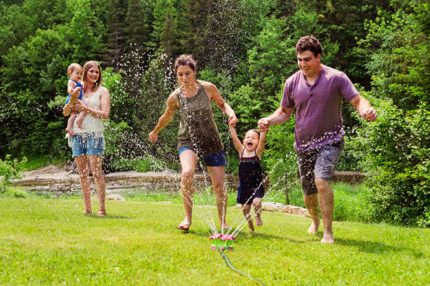 istock Millennials parents enjoying springkling water with baby daughters. 810942872