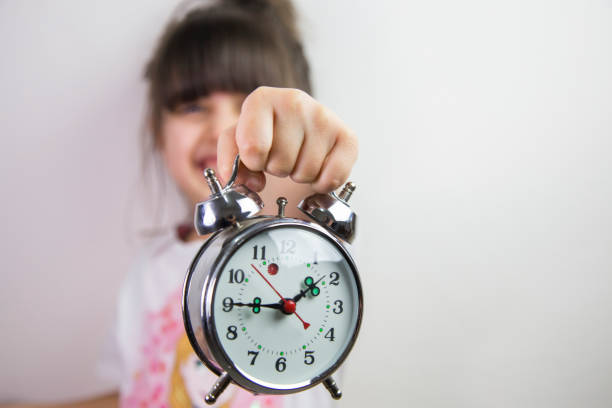 istock Little girl holding a clock. Work, school and time concept 810952366