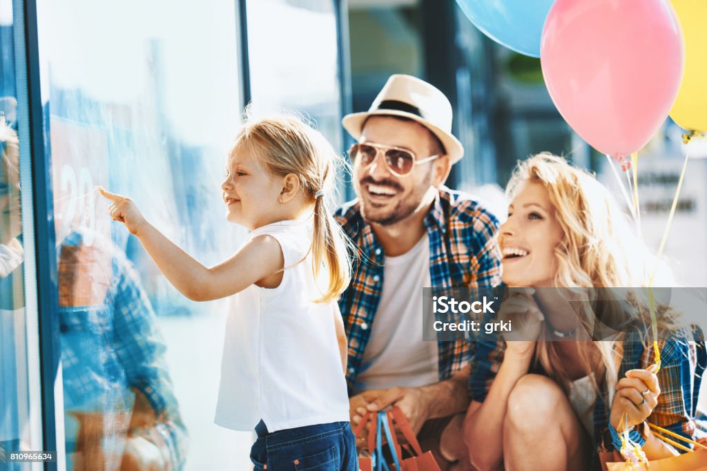 Family enjoying shopping Happy family with shopping bags and ballons walking on street. Family Stock Photo