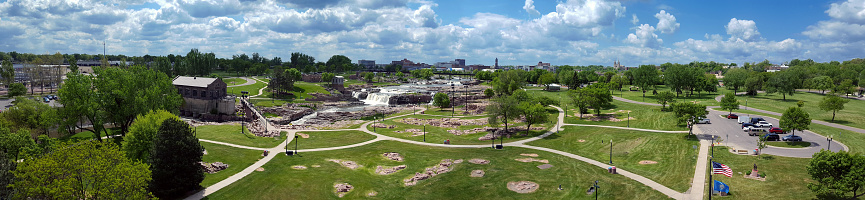 A full view of the Falls Park with a blue sky and green grass in May 2016.
