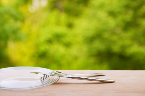 Simple table setting from above. Knife, spoon and fork, wine glass and napkin