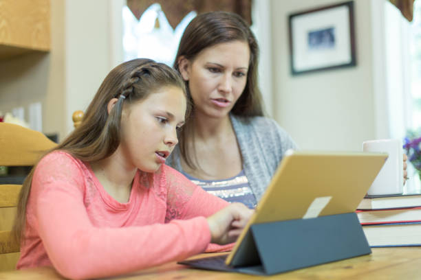 istock Mom and daughter studying together at kitchen table. 811000266