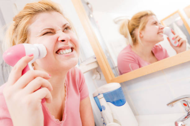 istock Shocked woman using facial cleansing brush 811010212