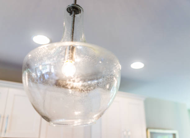 istock Macro closeup of transparent light modern fixture hanging from ceiling in kitchen 811036668