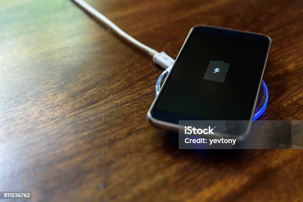 Smartphone Charging On A Charging Pad Wireless Charging Stock Photo - Download Image Now