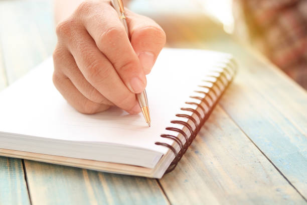 istock hand of people, student writing and note on notebook on wood table with copy space, in library, concept as education attempt and make effort to win, intend to improve knowledge for future life 811045882