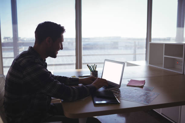 istock Young businessman using laptop on desk in office 811051142