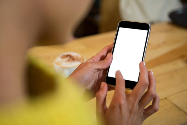 istock Woman using mobile phone at table in coffee shop 811089990