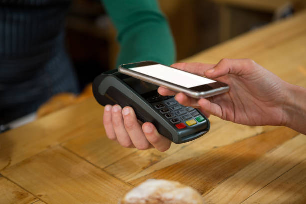 istock Barista accepting payment through smart phone in coffee shop 811091576