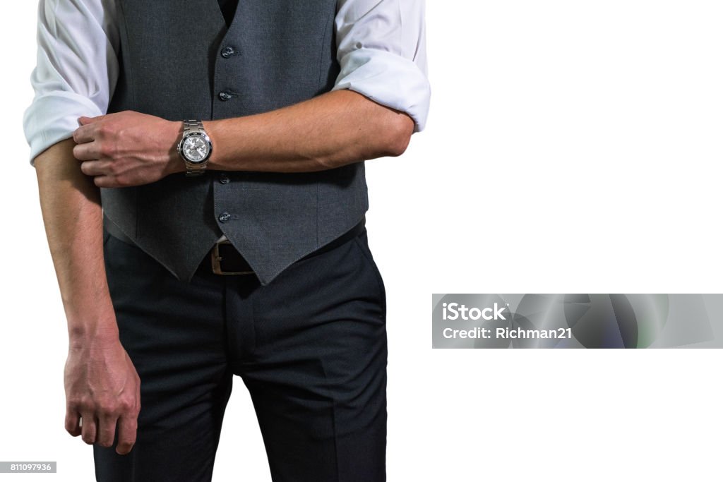 A young businessman in a white shirt rolls up his sleeves prepar A young businessman in a white shirt rolls up his sleeves preparing to work. A guy, a hipster in a gray waistcoat with a black tie. Ready for work Arm Stock Photo