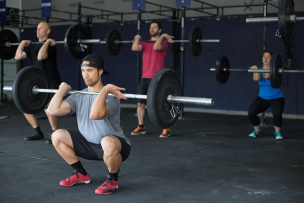 istock Mixed group of young adults lifting weights together at crosstraining gym 811098014
