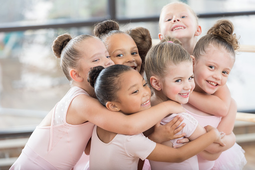 Jóvenes bailarinas forman un sonriente abrazo de grupo photo