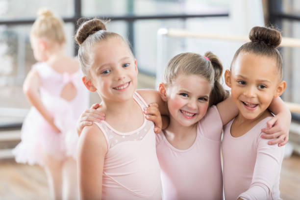 istock Three adorable young ballerinas smile arm in arm 811106214
