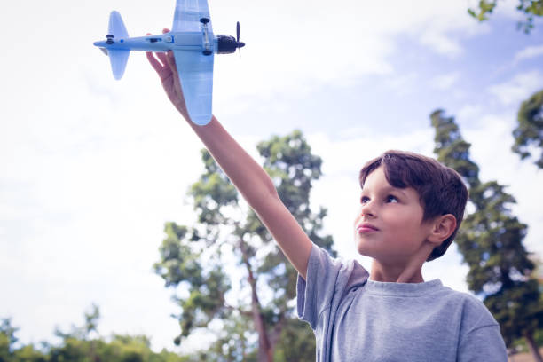 istock Boy playing with a toy plane at park 811119288