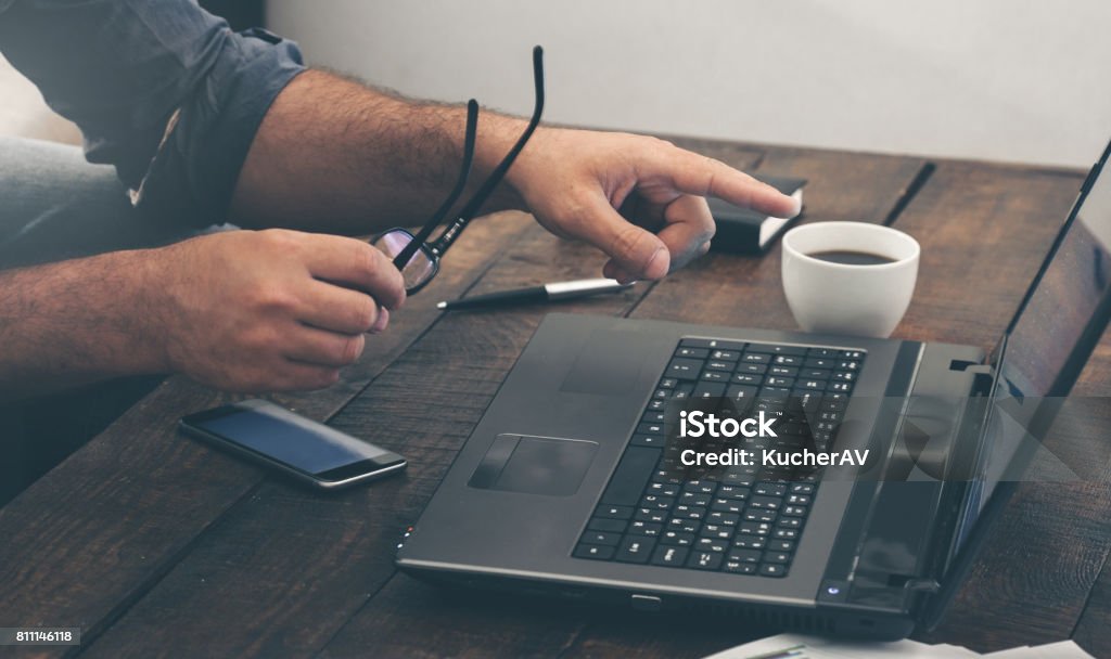 Businessman working with laptop at home office on wooden table Businessman working with laptop at home office on wooden table. Business background Web Conference Stock Photo