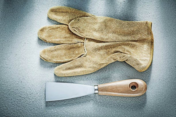 istock Putty knife leather protective gloves on concrete background con 811146314
