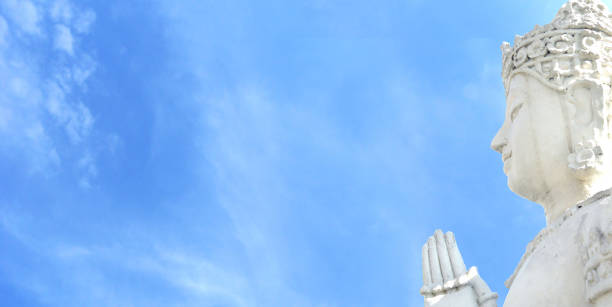 Side face of Buddha and heaven blue sky. The Side face of Avalokitesvara (Awalokitesuan) statue at temple of north in Thailand.