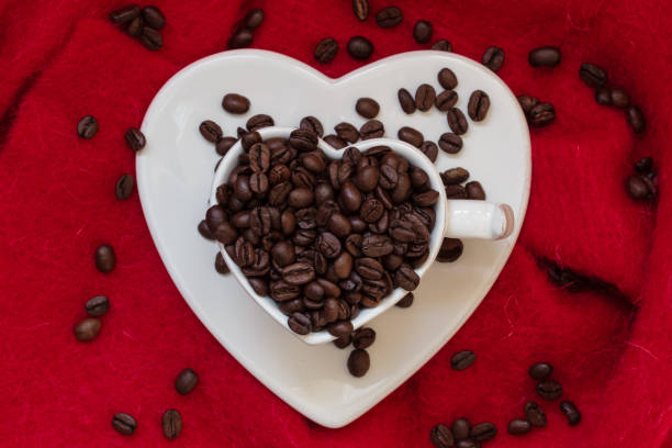 istock Heart shaped cup with coffee beans on red 811165512