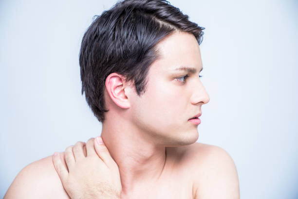istock young man having a pain in his neck 811171418