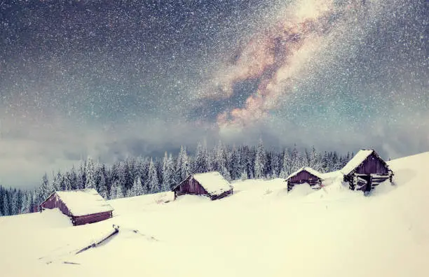 Photo of chalets in the mountains at night under the stars. Magic event in frosty day. In anticipation of the holiday