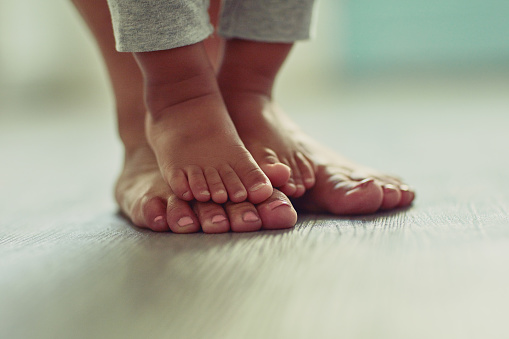 Shot of an unrecognizable mother's feet and her child's feet at home