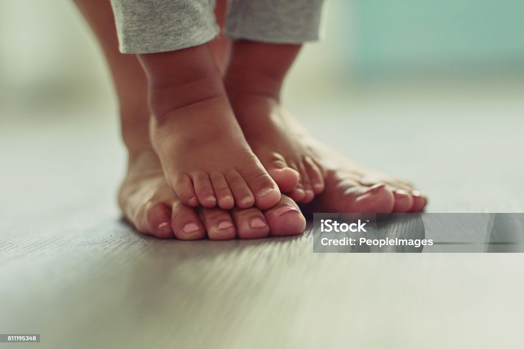 Little feet make my life so very sweet Shot of an unrecognizable mother's feet and her child's feet at home Foot Stock Photo