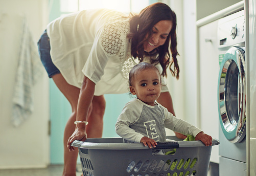 Shot of a mother and her adoarable baby boy doing the laundry at home