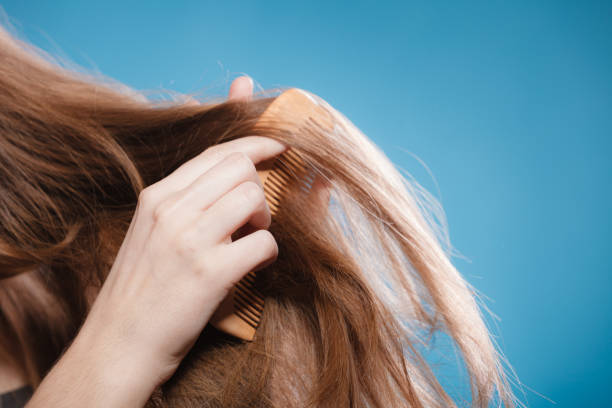 istock Female hand combing hair with wooden comb 811202348