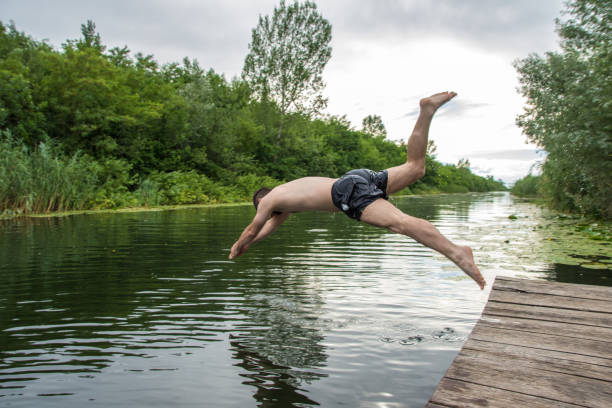 istock Young man enjoying summer day by the water, swimming 811211262