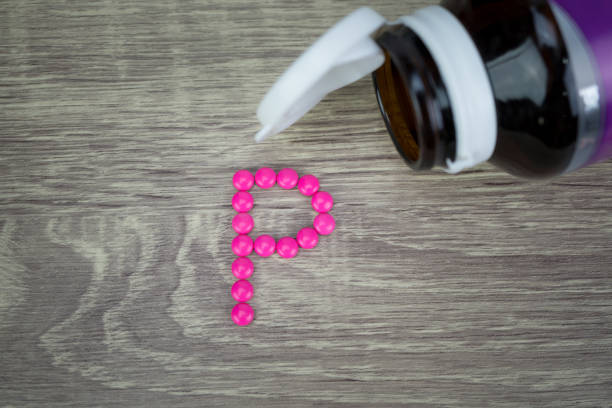 istock Pink pills forming shape to P alphabet on wood background 811215278
