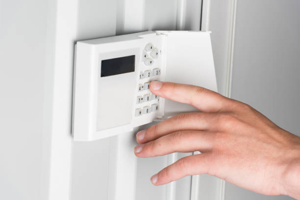 istock cropped view of person typing password on home security alarm, security system concept 811219960
