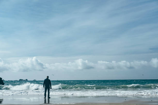 istock Man stood on Kynance Cove beach. 811219988