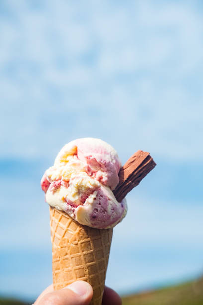 istock Hand holding strawberry ice-cream cone, South Cornwall Coast. 811220016