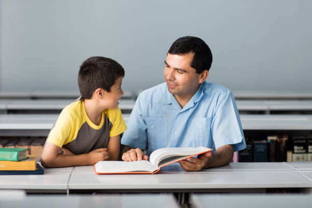 istock Father and son looking at book in the library 811220188