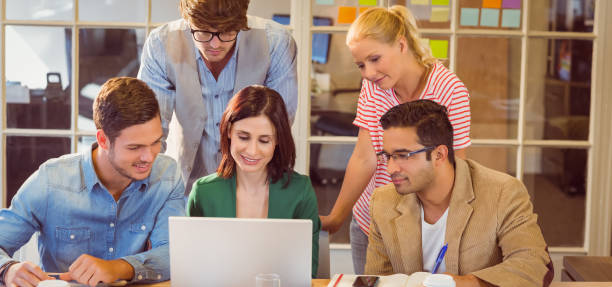 istock Happy creative business team using laptop in meeting 811233406