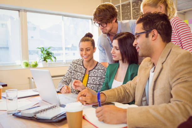 istock Happy creative business team using laptop in meeting 811233748