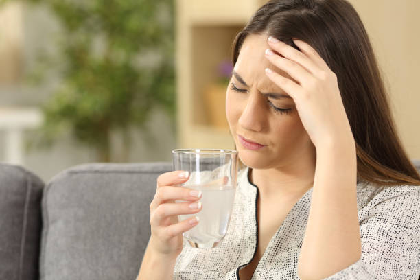 istock Woman suffering head ache holding a glass 811240590